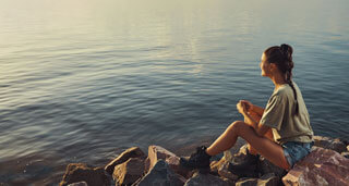female on rocky shore during her los angeles luxury detox treatment