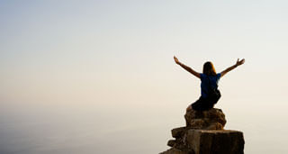 a woman cheering on top of rock for completing methadone detoxing