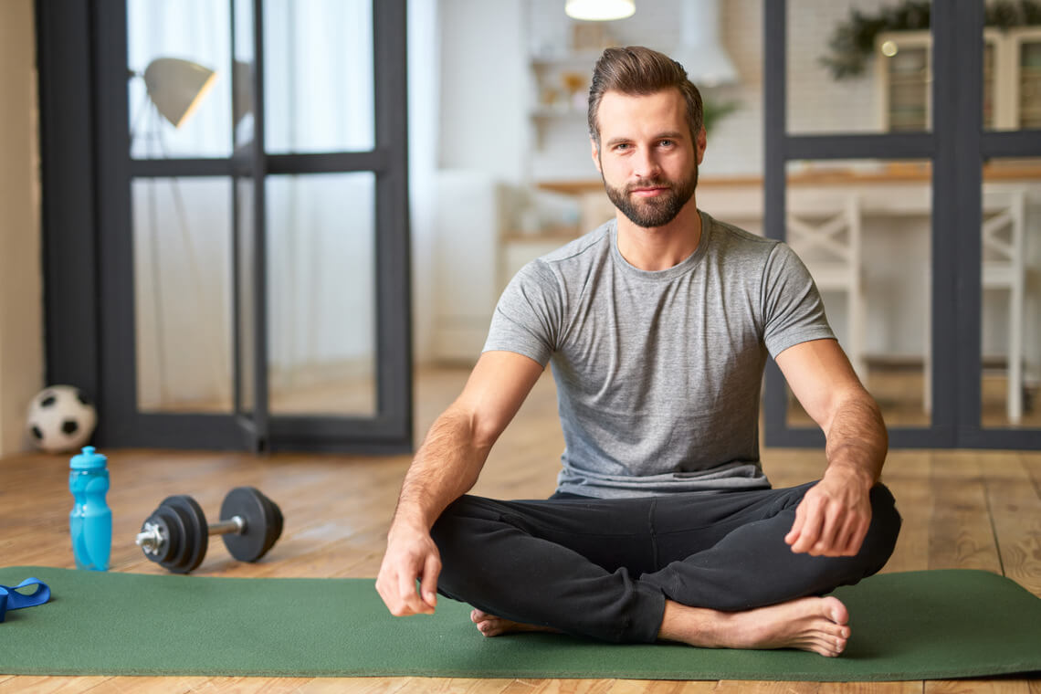 a man sitting on the floor with a green mat while detoxing