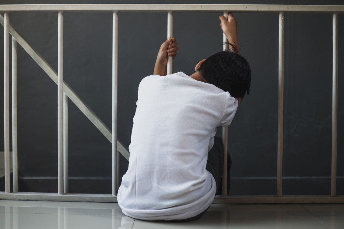 a man experiencing withdrawal with opioid is sitting on the stairs and holding the rails