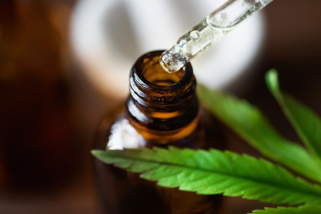 a picture of a cbd oil being taken by a drops from a bottle
