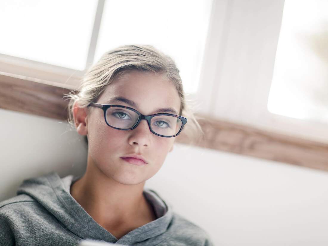 a teen wearing a black glasses in a residential treatment facility